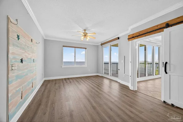 a view of empty room with wooden floor and fan