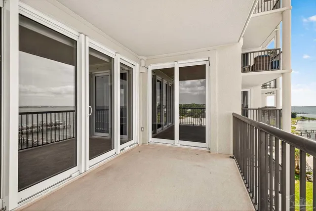 a view of a hallway with wooden floor and a bathroom