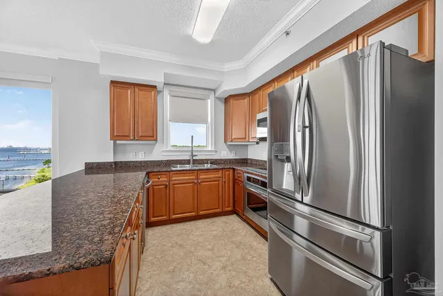 a large white kitchen with a sink and a large window