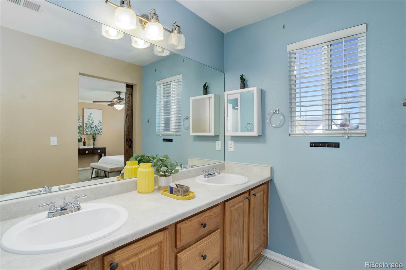 2471 South Andes Circle Aurora, CO 80013 - Photo 21 of 35 a bathroom with a sink a large mirror and a light fixture