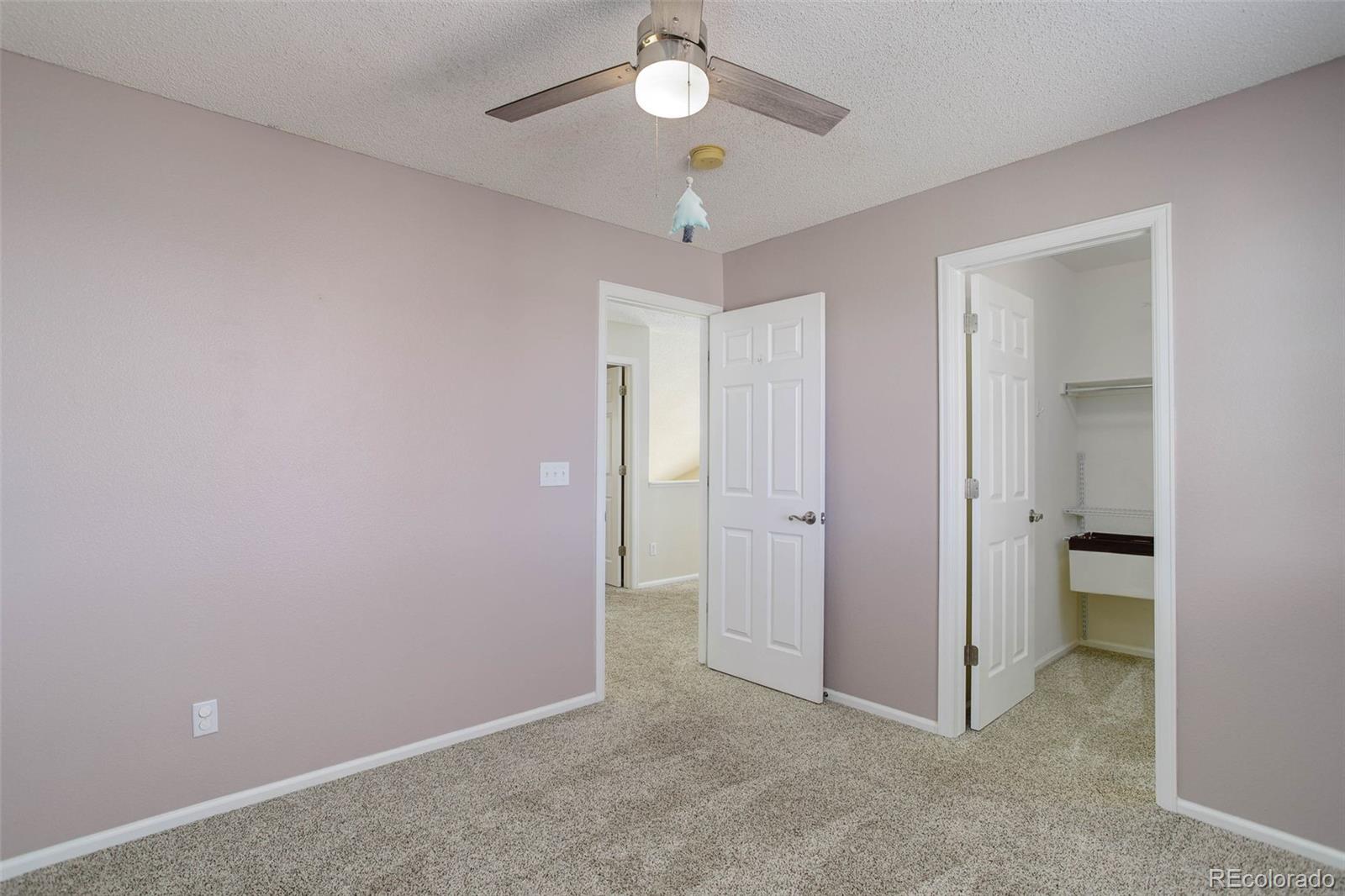 2471 South Andes Circle Aurora, CO 80013 - Photo 23 of 35 an empty room with a chandelier fan and closet area