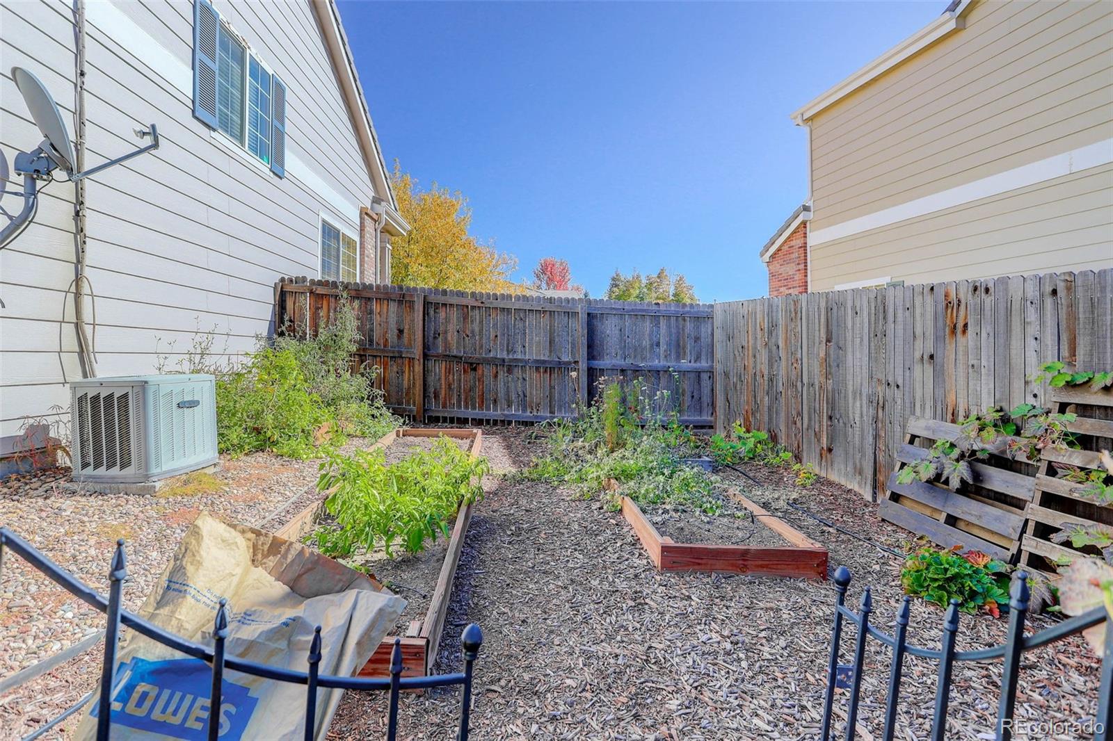 2471 South Andes Circle Aurora, CO 80013 - Photo 32 of 35 a view of a backyard with chairs potted plants and wooden fence