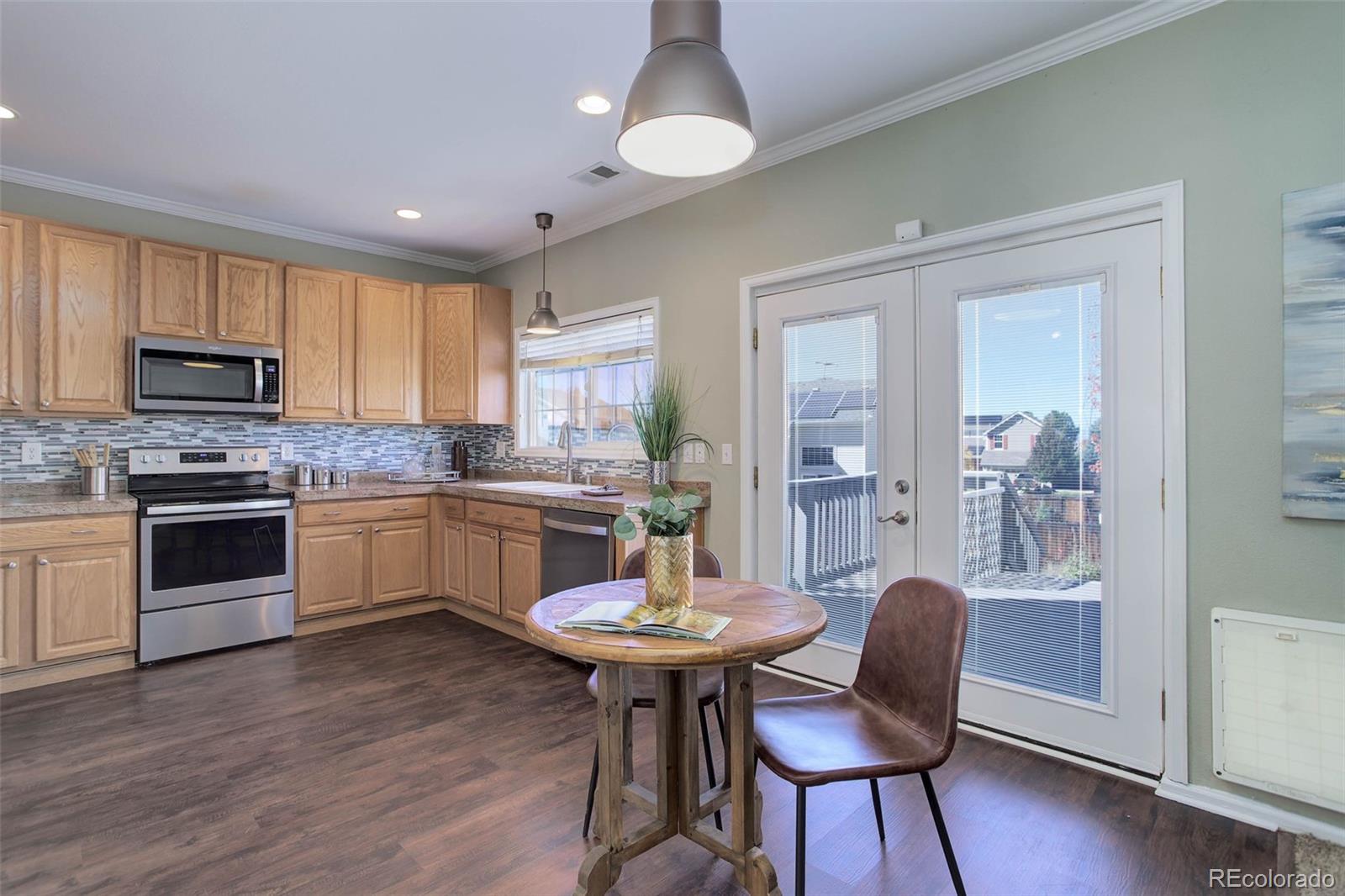 2471 South Andes Circle Aurora, CO 80013 - Photo 8 of 35 a kitchen with a dining table chairs stainless steel appliances and cabinets
