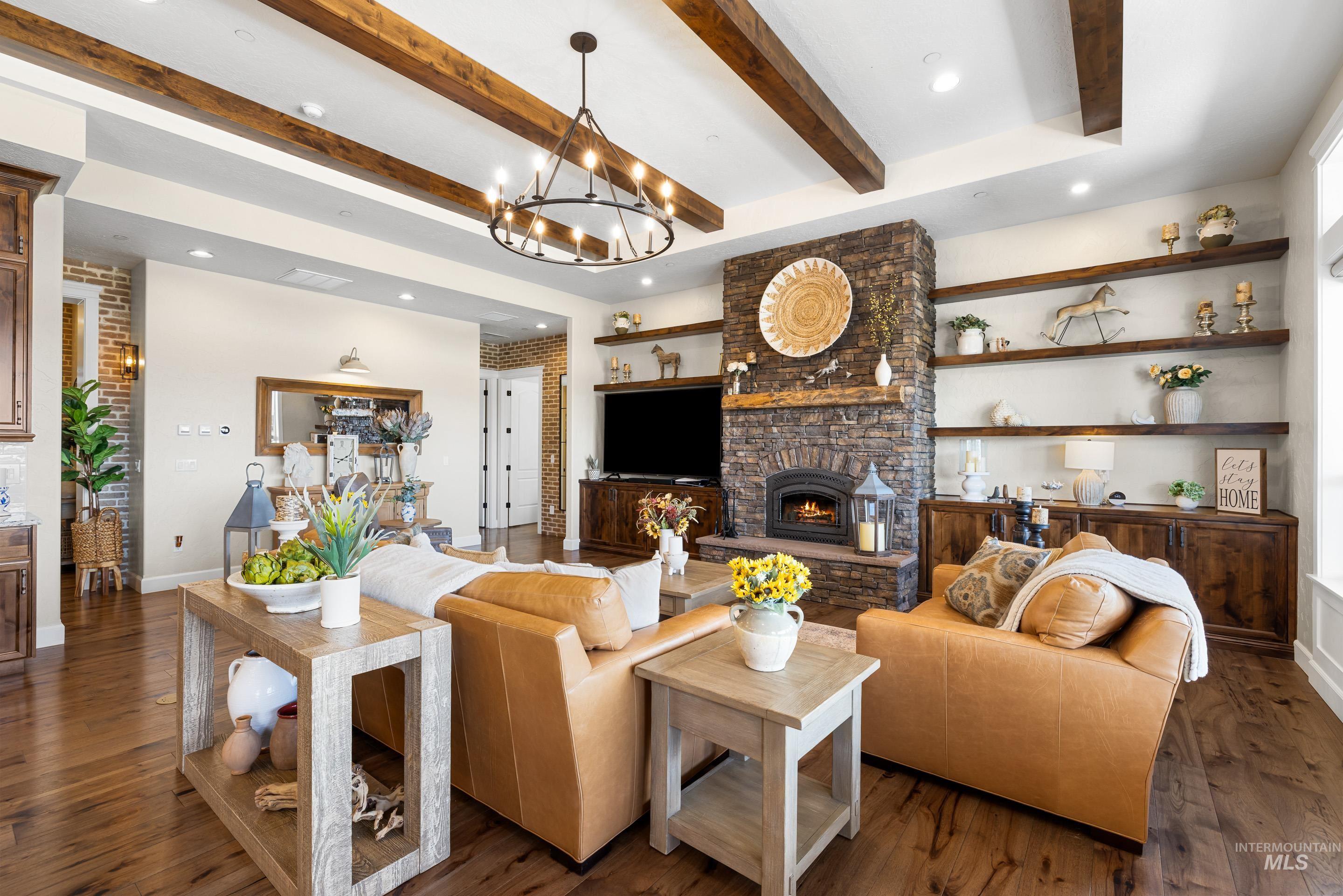 9819 Foothill Road Middleton, ID 83644 - Photo 16 of 50 Living room with a fireplace, beamed ceiling, dark wood finished floors, recessed lighting, and a chandelier
