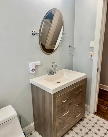 a bathroom with a sink a toilet and a mirror