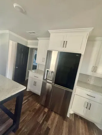 a view of a refrigerator in kitchen and wooden floor
