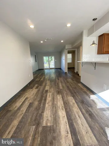 a view of an empty room and kitchen view