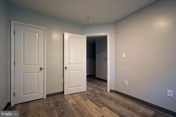 an empty room with wooden floor and closet