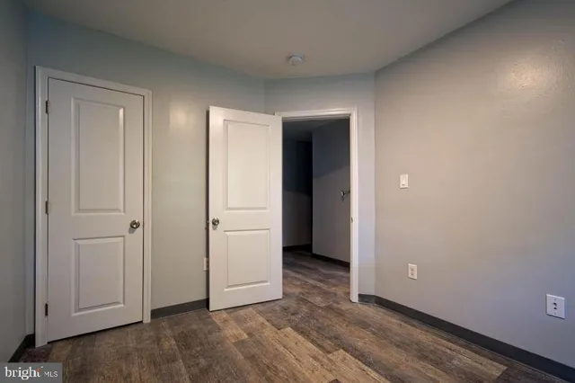 an empty room with wooden floor and closet