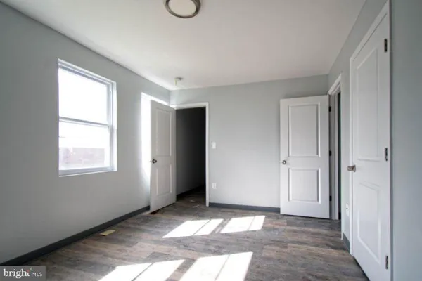 a view of an empty room with window and closet area