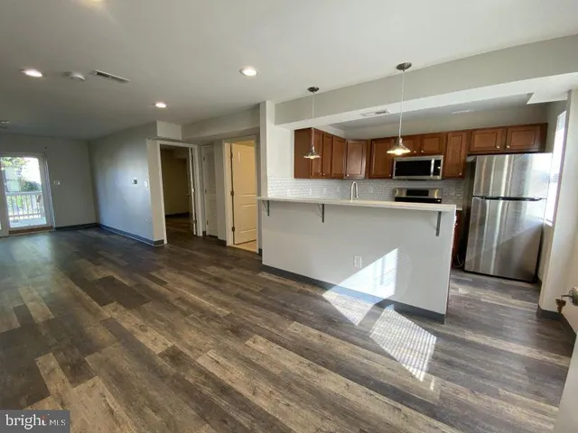 a kitchen with stainless steel appliances granite countertop a refrigerator a sink a stove and oven