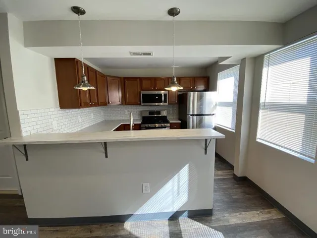 a kitchen with stainless steel appliances a refrigerator and a stove top oven
