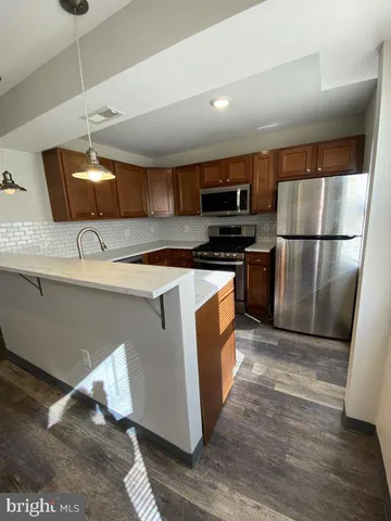 a kitchen with stainless steel appliances granite countertop a refrigerator a stove a sink and a microwave