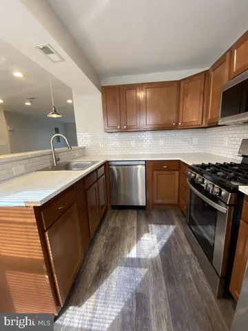a kitchen with stainless steel appliances granite countertop a sink stove and cabinets