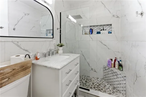 a bathroom with a granite countertop sink a toilet and a mirror