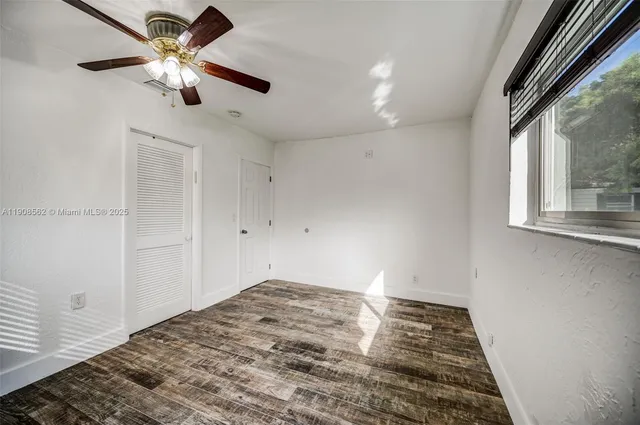 a view of a livingroom with a ceiling fan and window