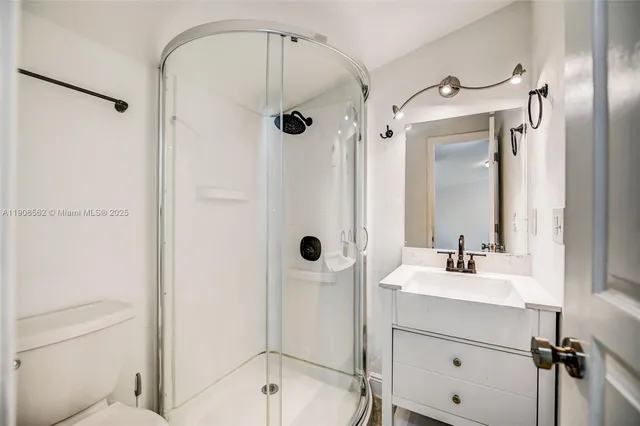 a bathroom with a shower sink vanity and mirror