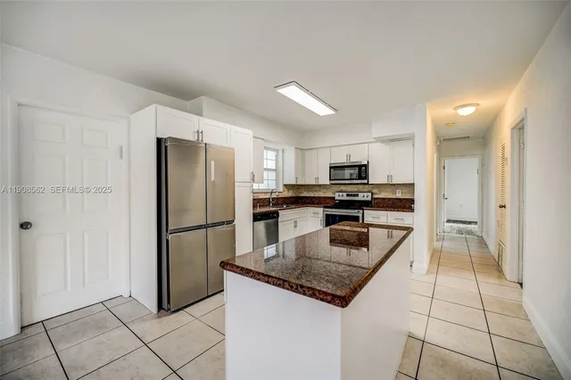 a kitchen with a refrigerator a microwave and a sink