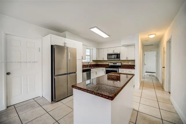 a kitchen with a refrigerator a microwave and a sink