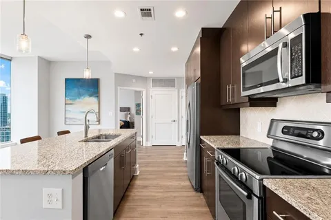 a kitchen with stainless steel appliances granite countertop a sink stove and microwave