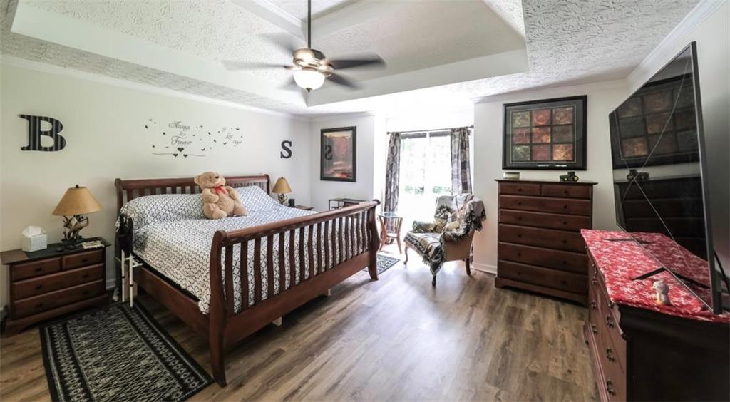 6945 John Rivers Road Fairburn, GA 30213 - Photo 11 of 65 a bedroom with a bed and wooden floor