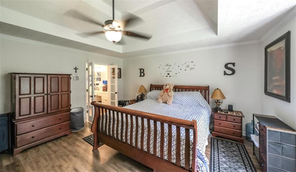 6945 John Rivers Road Fairburn, GA 30213 - Photo 20 of 65 a bedroom with a bed and a chandelier