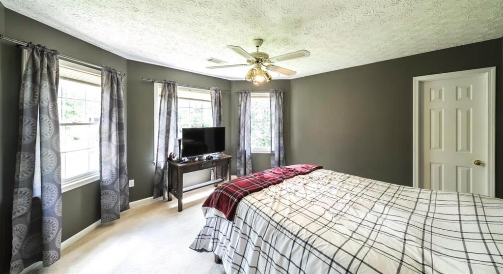 6945 John Rivers Road Fairburn, GA 30213 - Photo 27 of 65 a bedroom with a bed and a flat screen tv