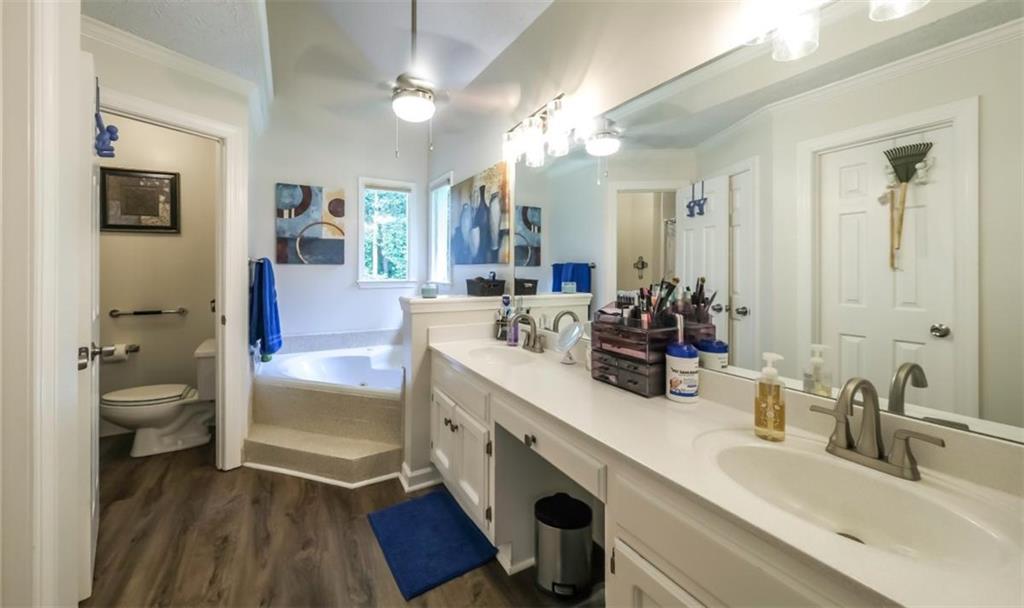 6945 John Rivers Road Fairburn, GA 30213 - Photo 38 of 65 a bathroom with a double vanity sink a mirror and a bathtub