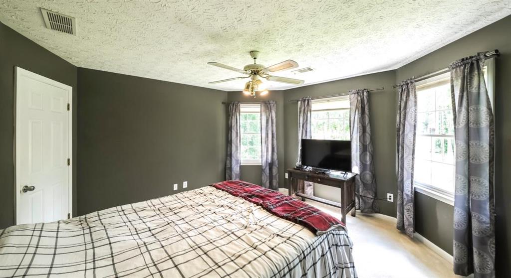 6945 John Rivers Road Fairburn, GA 30213 - Photo 44 of 65 a bedroom with a bed and a chandelier