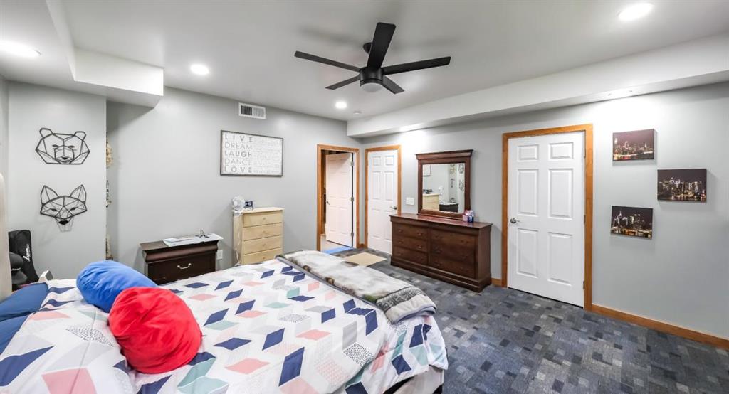 6945 John Rivers Road Fairburn, GA 30213 - Photo 45 of 65 a bedroom with a bed and a chandelier