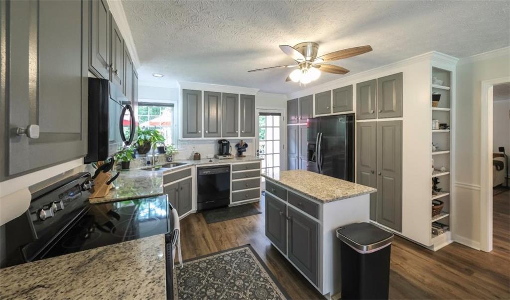 6945 John Rivers Road Fairburn, GA 30213 - Photo 52 of 65 a kitchen with a stove a refrigerator and a sink