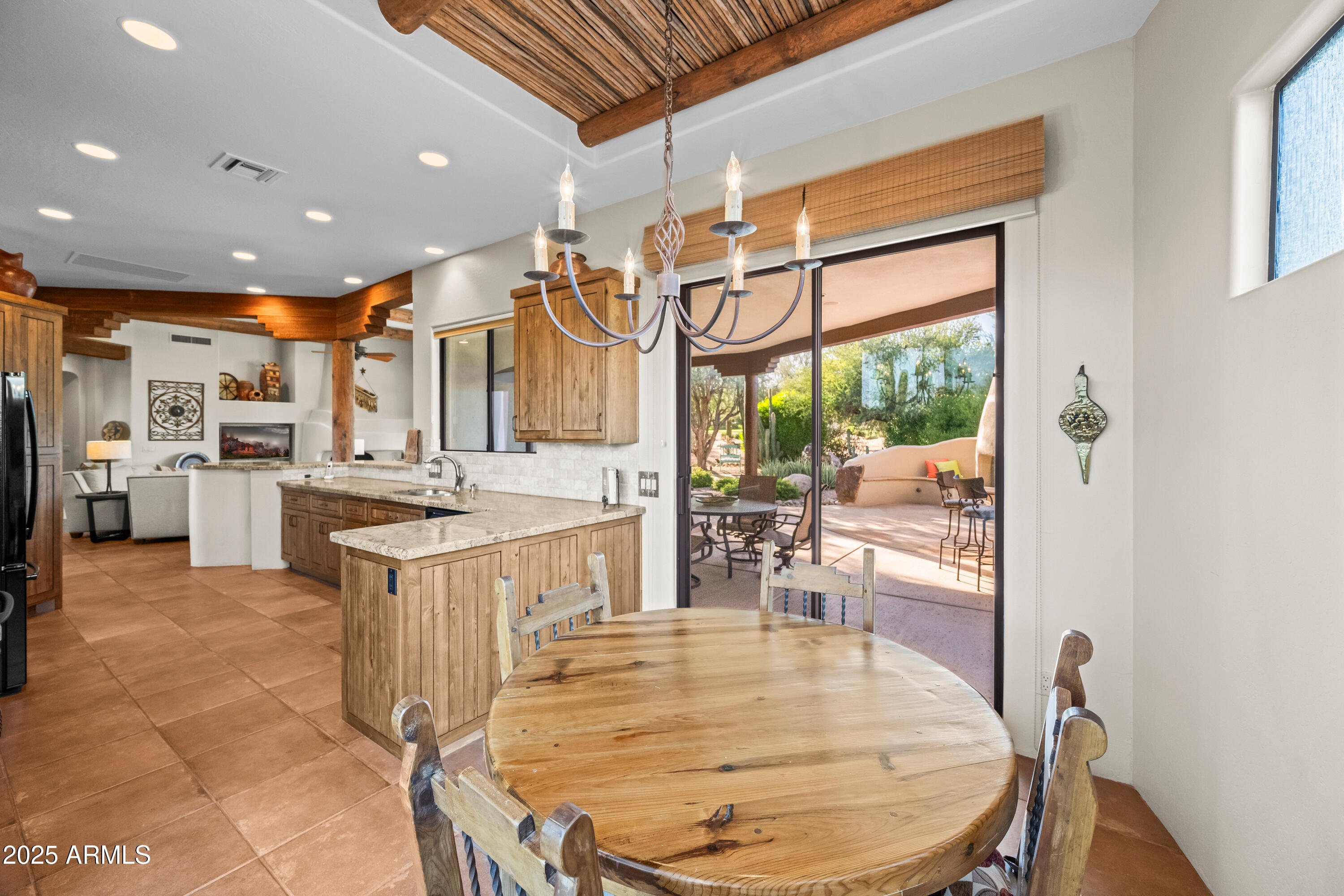 26708 North Aguila Road Rio Verde, AZ 85263 - Photo 17 of 46 a kitchen with stainless steel appliances kitchen island granite countertop a table chairs in it and wooden floors