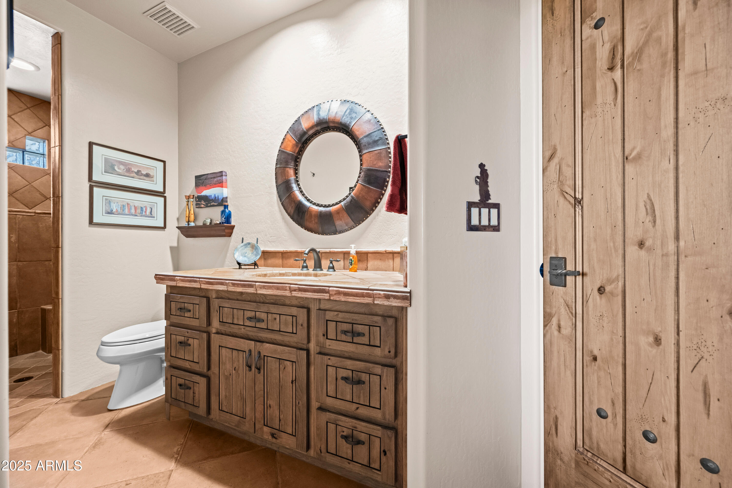 26708 North Aguila Road Rio Verde, AZ 85263 - Photo 33 of 46 a bathroom with a toilet a sink and a mirror