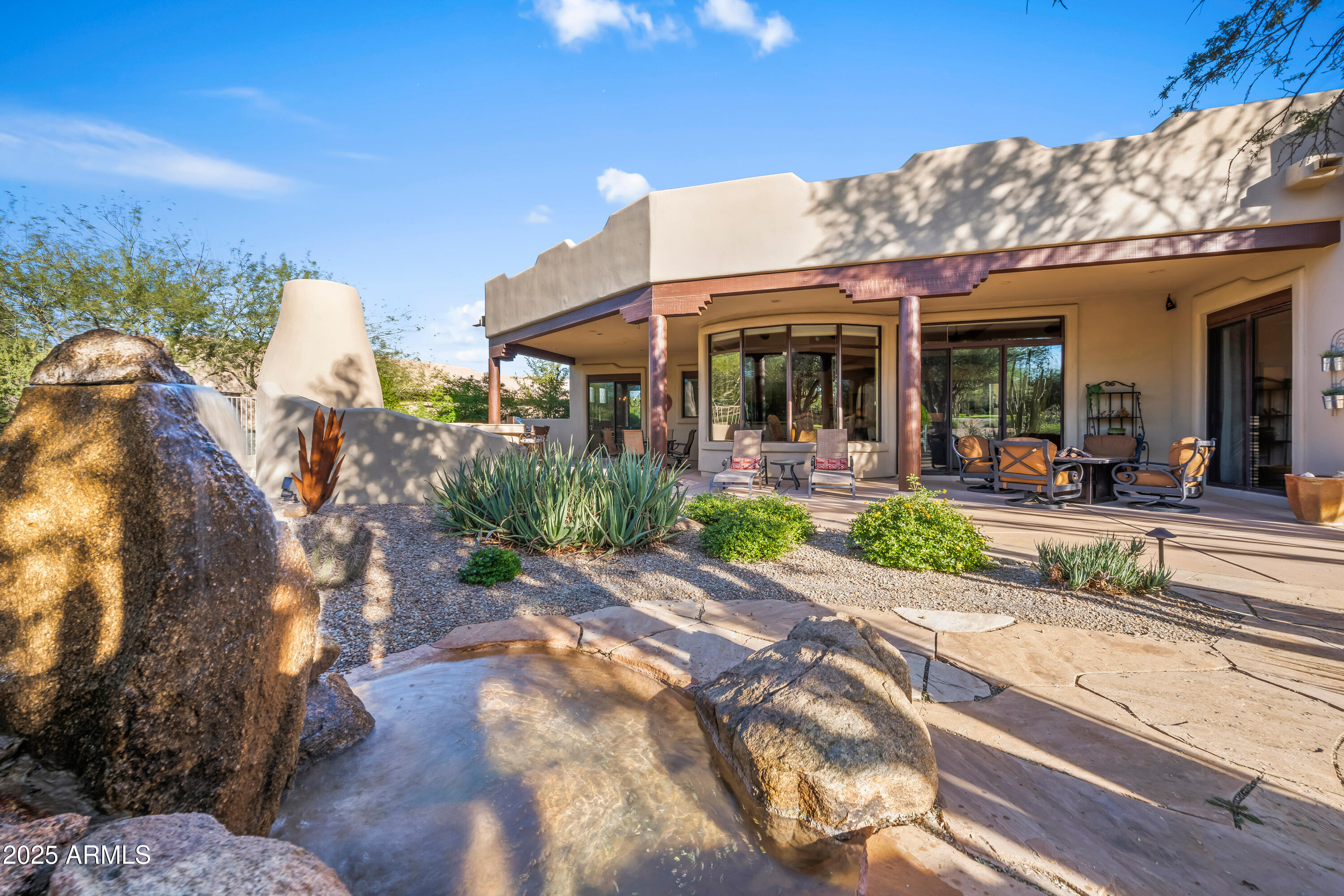 26708 North Aguila Road Rio Verde, AZ 85263 - Photo 41 of 46 a view of a patio with table and chairs under an umbrella next to a road