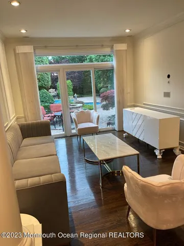 a living room with furniture a large window and wooden floor