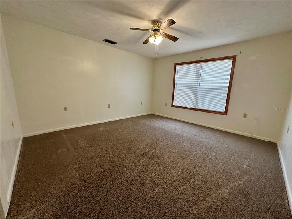 520 Southwest 5th Avenue Lake Butler, FL 32054 - Photo 5 of 54 an empty room with windows and fan