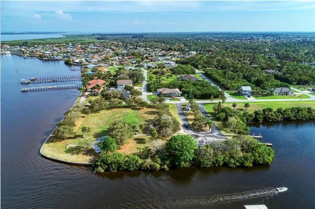 an aerial view of a house with a yard and lake view in back