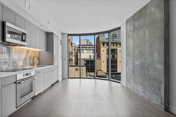 a large white kitchen with granite countertop a stove and a sink