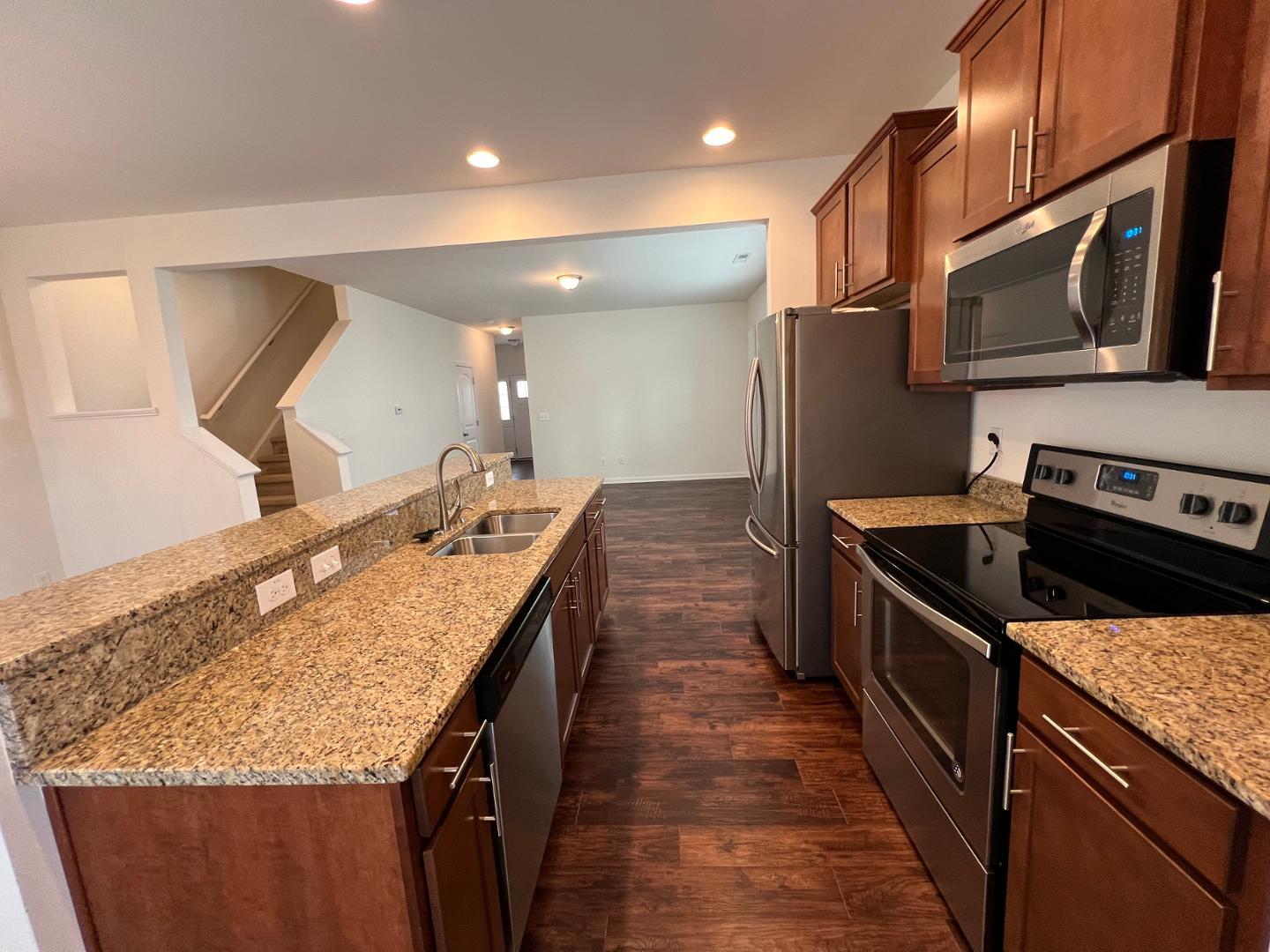 219 Cross Blossom Road Durham, NC 27703 - Photo 11 of 35 a kitchen with stainless steel appliances granite countertop a sink stove and refrigerator