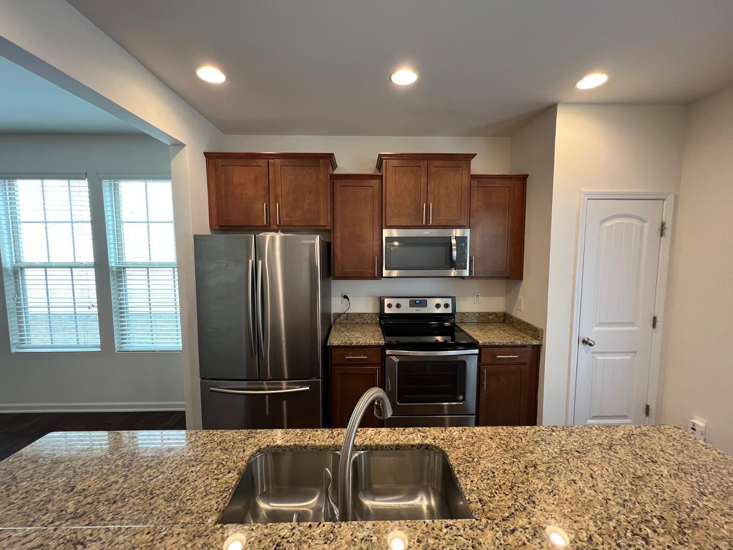 219 Cross Blossom Road Durham, NC 27703 - Photo 12 of 35 a kitchen with kitchen island granite countertop a refrigerator stove top oven and sink