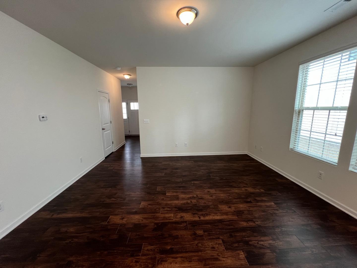 219 Cross Blossom Road Durham, NC 27703 - Photo 13 of 35 a view of an empty room with wooden floor and a window