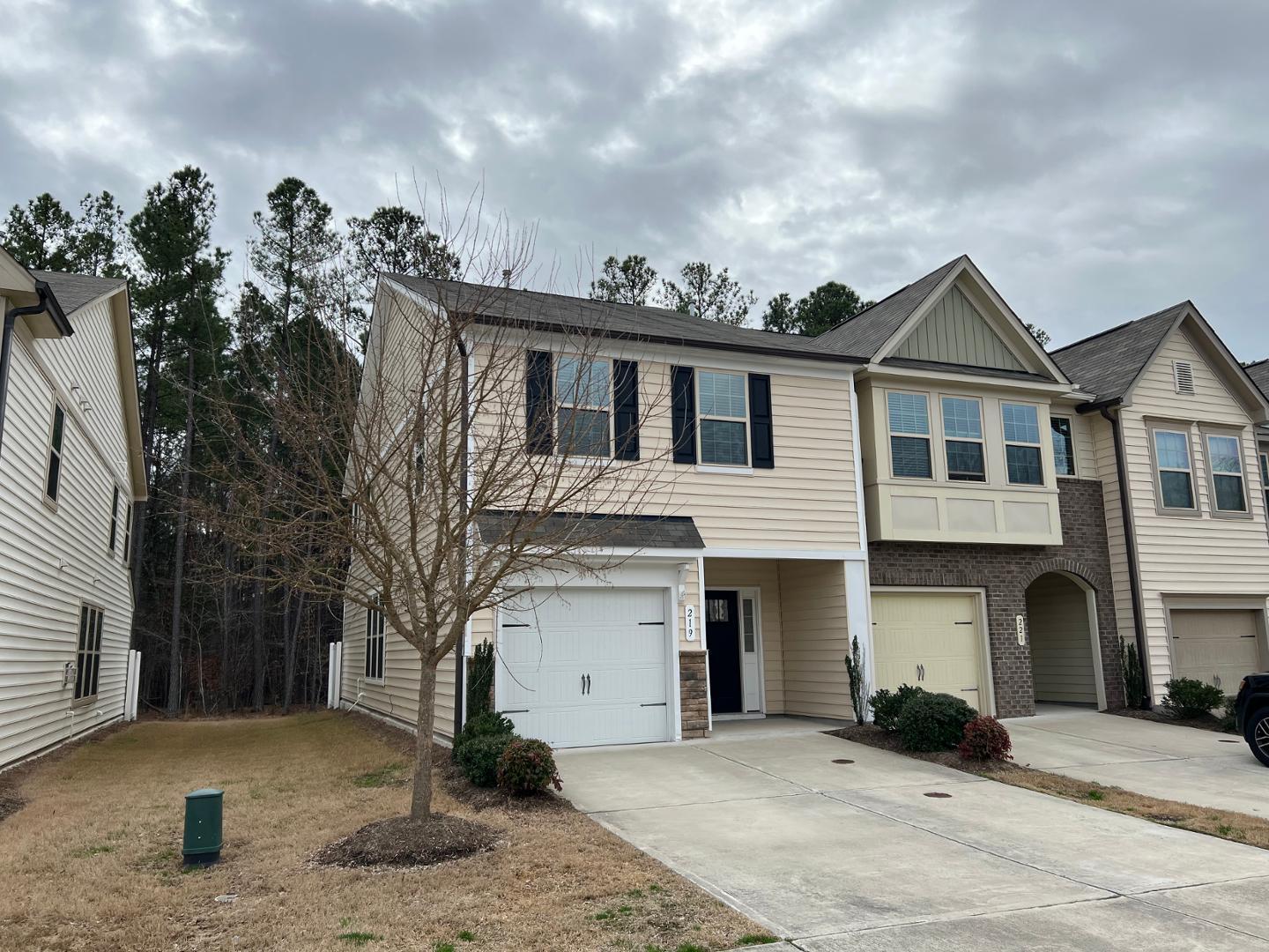 219 Cross Blossom Road Durham, NC 27703 - Photo 2 of 35 a front view of a house with a yard and garage