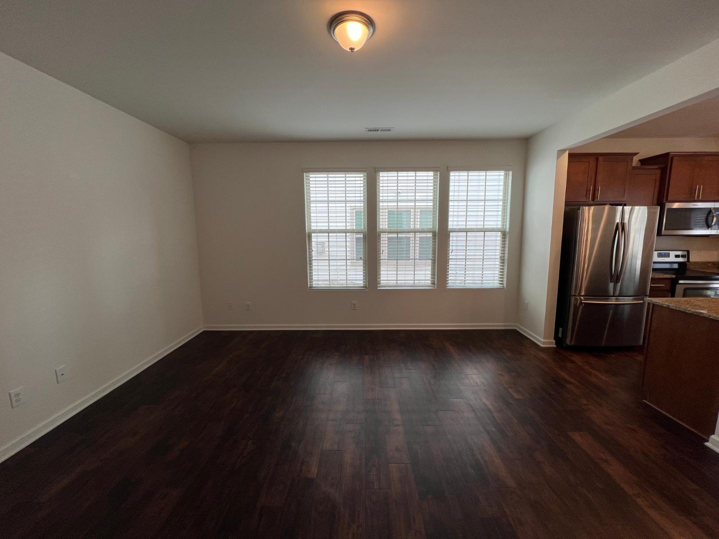 219 Cross Blossom Road Durham, NC 27703 - Photo 4 of 35 an empty room with wooden floor and windows