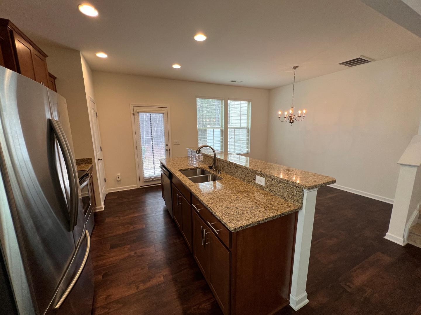 219 Cross Blossom Road Durham, NC 27703 - Photo 7 of 35 a kitchen with stainless steel appliances granite countertop a refrigerator a sink a stove and wooden floor