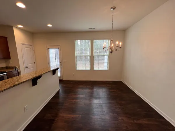 a view of big room with wooden floor and windows