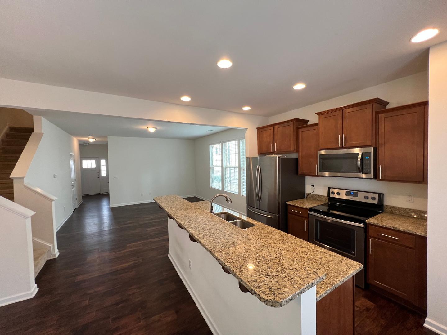 219 Cross Blossom Road Durham, NC 27703 - Photo 10 of 35 a kitchen with stainless steel appliances granite countertop a sink stove and refrigerator