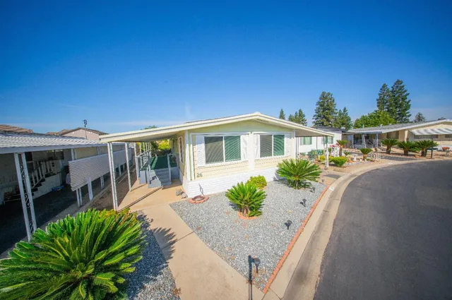 a front view of a house with a yard glass top table and chairs