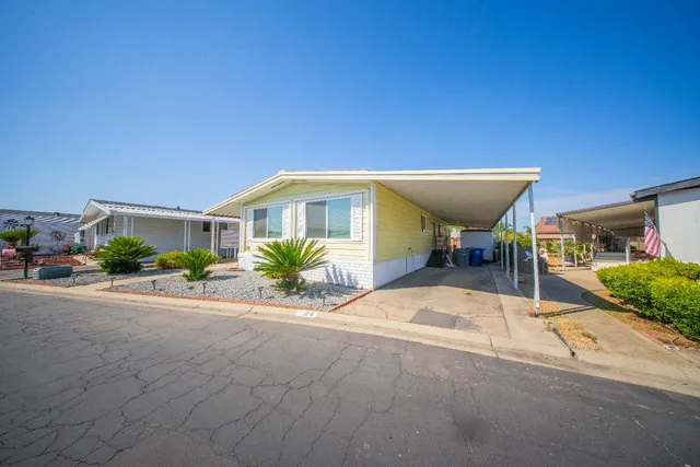 a view of a house with backyard and sitting area