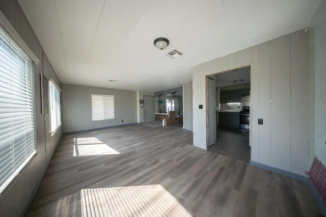 a view of hallway with wooden floor and cabinet