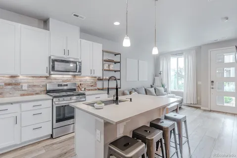 a kitchen with a stove a sink and a refrigerator